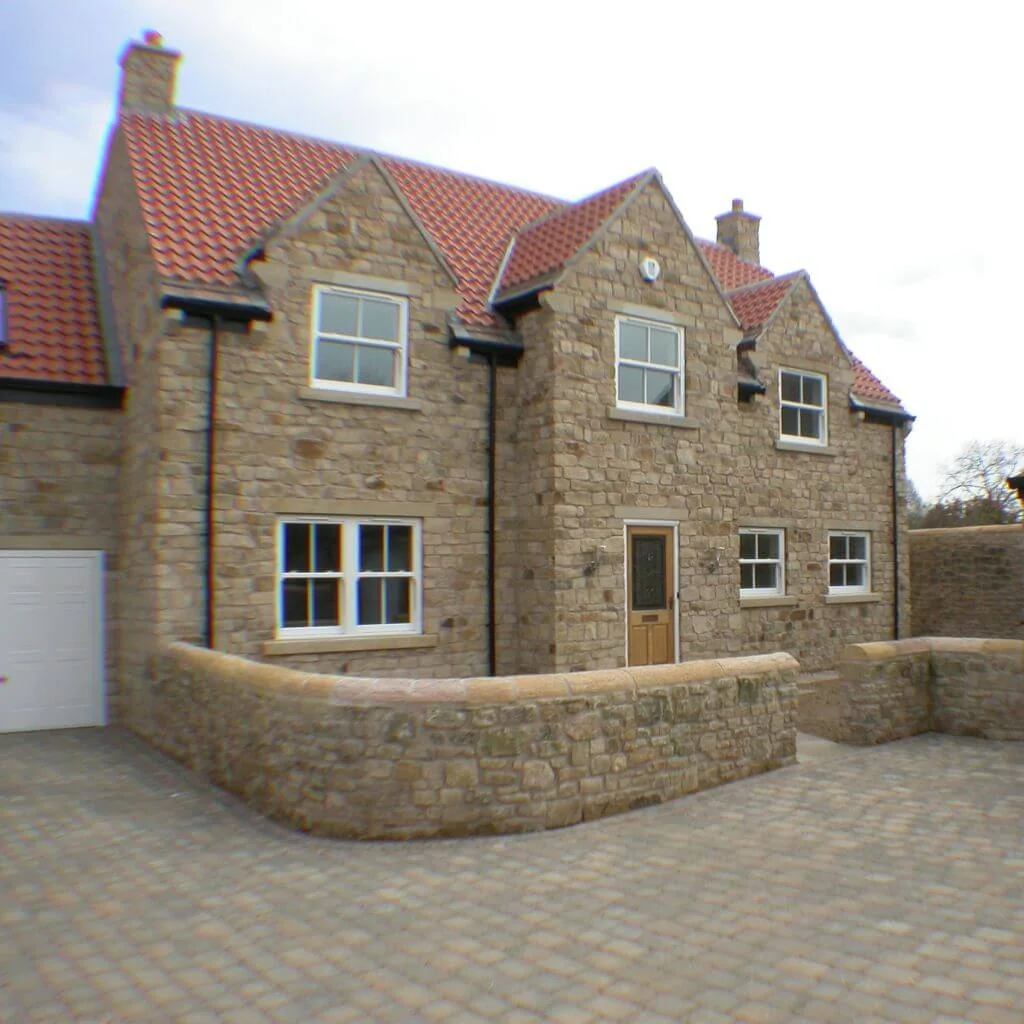 Stone new build home with bay windows